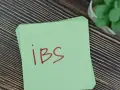 Napis "ibs" czerwonym markerem na zielonej kartce.