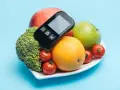 Zdrowa dieta dla cukrzyka: brokuły, pomarańcza, jabłka i pomidorki. Glukometr na talerzu.