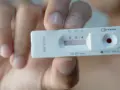 Dłoń trzyma test na HIV z widocznym wynikiem.
