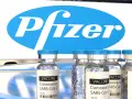 Szczepionki Pfizer na COVID-19 w ampułkach, z logo firmy w tle.