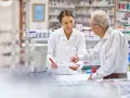 Farmaceutka pomaga seniorowi zrealizować receptę na darmowe leki.