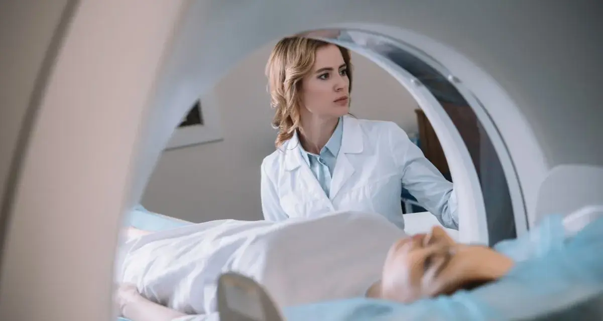 Lekarka nadzoruje badanie rezonans serca. Pacjent leży na stole diagnostycznym wewnątrz aparatu MRI.