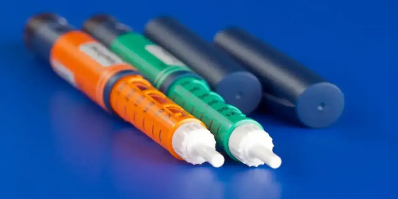 Trzy wstrzykiwacze, dwa kolorowe (pomarańczowy i zielony) z podziałką, oraz dwa granatowe. Sprawdź aktualną epipen cena.