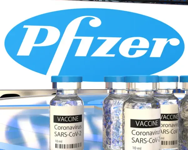 Szczepionki Pfizer na COVID-19 w ampułkach, z logo firmy w tle.